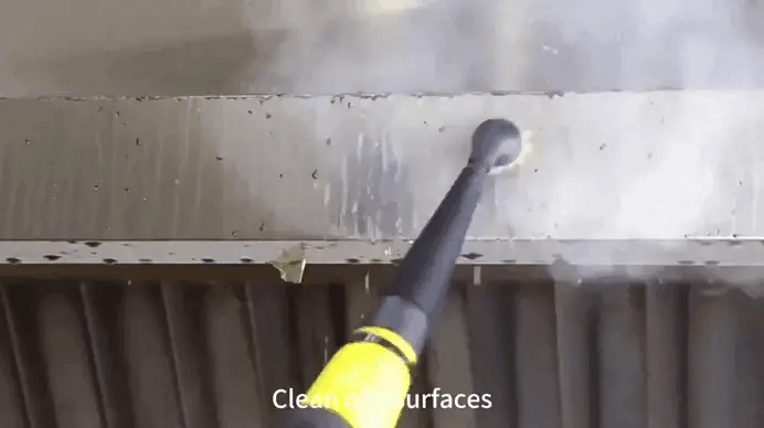Powerful steam from handheld cleaner blasting dirt from greasy metal surface.