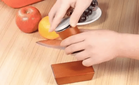 Hand pressing lightly on the magnetic roller top of the knife sharpener for effortless sharpening