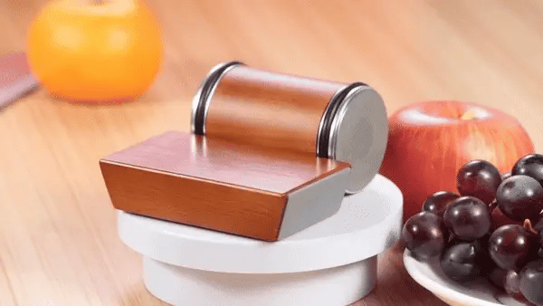 Magnetic Rolling Knife Sharpener with wood grain finish placed beside fruits on a kitchen counter