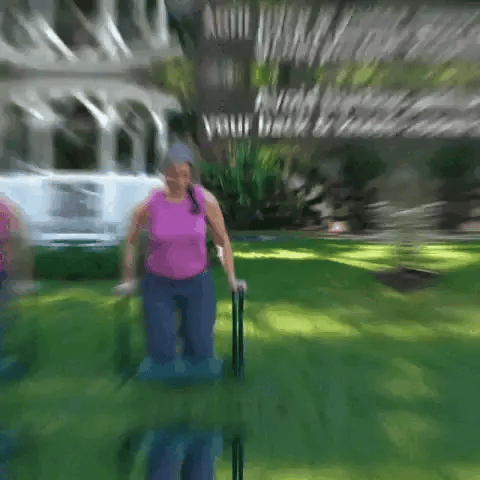 Woman sitting on Folding Garden Kneeler Bench outdoors to reduce back and knee strain while gardening
